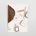 Cream journaling card with a brown makeup bag, powder compacts, a pink perfume bottle, lip balm, and a pearl hair clip
